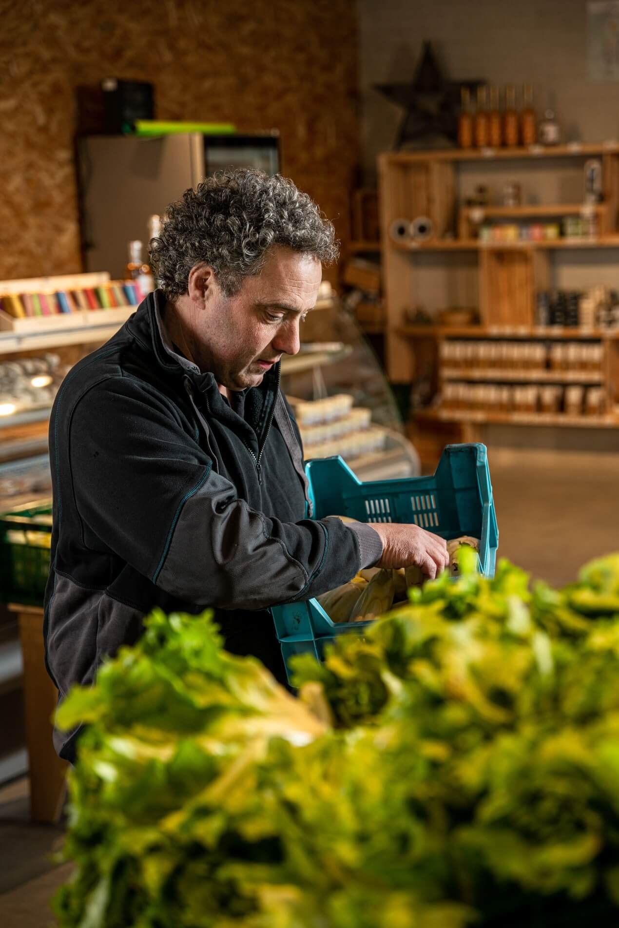 focus sur fermier rangeant des produits frais à la grange gourmande